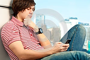 Trendy young guy typing a message