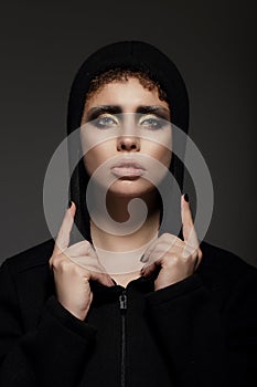 Trendy Young Woman in Hood over Black Background