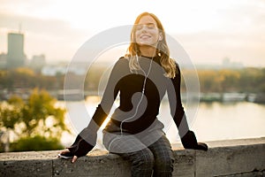 Trendy young woman listening music from smartphone outdoor