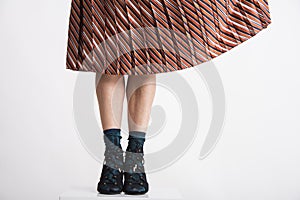 Trendy young woman`s legs with aery flitting skirt.