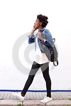 Trendy young woman walking outside and talking on mobile phone
