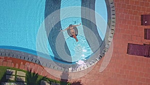 Trestles by hotel pool and woman in water on ring