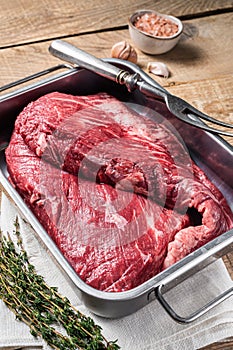 Tri Tip beef steak in steel tray, raw prime meat. Wooden background. Top view