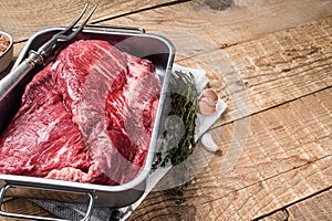 Tri tip beef steak in steel tray, raw prime meat. Wooden background. Top view. Copy space