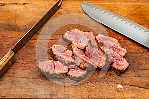 rare grade tri-tip steak sliced on cutting board