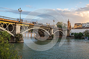 Triana Bridge and Castle of San Jorge at Guadalquivir River at sunset - Seville, Spain photo