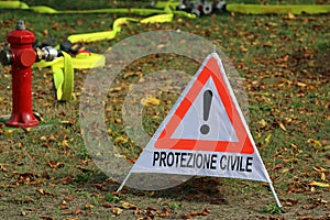 Triangle with exclamation mark and text in Italian which means CIVIL PROTECTION and a fire hydrant photo