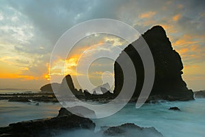 Triangle Rock at middle of the sea with smooth wave