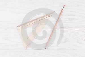 Triangle ruler and pencil on wooden background
