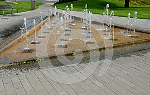 A triangle with water splashing in regular rows where the water in the jet flies upwards from the grid. in scenic waves alternatin