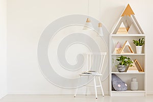 Triangles on shelves in scandi kid`s room interior with white ch