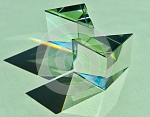 Triangular clear prism refracting and reflecting beam of light into spectrum colors