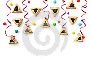 Triangular cookies with poppy seeds  hamantasch or aman ears , colored candy and red serpentine for jewish holiday of purim