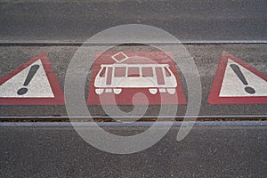 Triangular danger symbols on the ground between tram rails at a tram crossing
