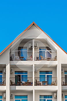 Triangular facade of a modern building interior, a hotel exterior against a blue sky