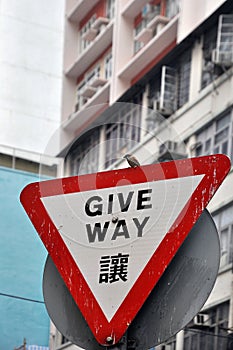 Triangular give way traffic warning board and a bird