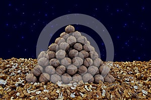 Triangular pyramid of whole walnuts among walnut kernels