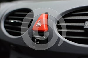 Triangular red hazard flasher button inside car interior