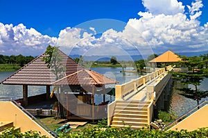 The triangular roof has a long corridor to the middle of the water, with green mountains, white clouds and blue skies.