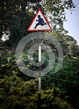 Triangular school ahead sign plate near the road