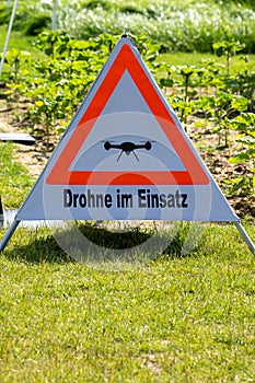 A triangular sign with a drone on it
