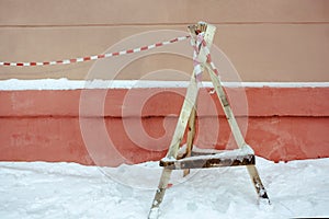 triangular wooden support and warning tape - protection from falling icicles on the street