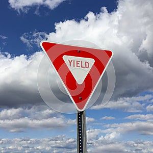 Triangular yield sign against a blue sky