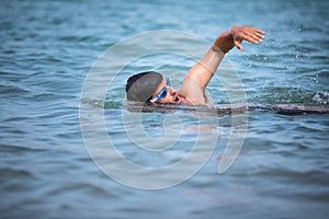 Triathlete man swimming freestyle crawl in ocean