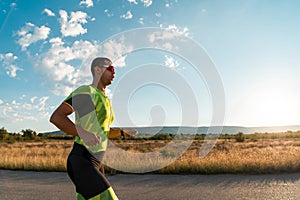 Triathlete in professional gear running early in the morning, preparing for a marathon, dedication to sport and