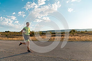 Triathlete in professional gear running early in the morning, preparing for a marathon, dedication to sport and