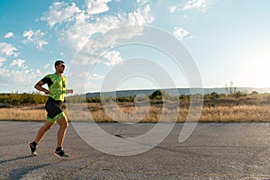 Triathlete in professional gear running early in the morning, preparing for a marathon, dedication to sport and
