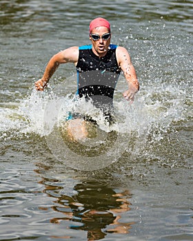 Triathlete is running out ot the water photo