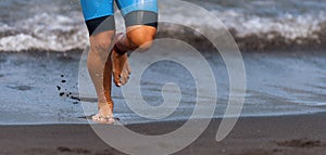 Triathlete swimmer running out of ocean finishing swim race