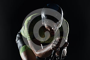 Triathlon athlete riding bike fast at night