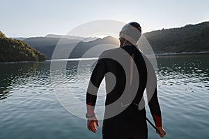 Triathlon athlete starting swimming training on lake