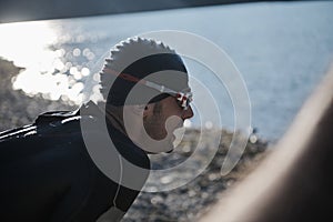 Triathlon athlete starting swimming training on lake