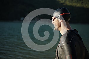 Triathlon athlete starting swimming training on lake