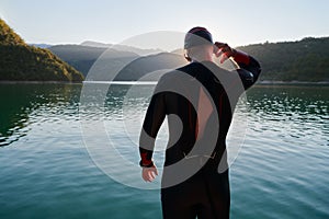 Triathlon athlete starting swimming training on lake