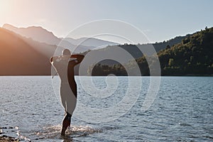 Triathlon athlete starting swimming training on lake