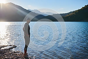Triathlon athlete starting swimming training on lake