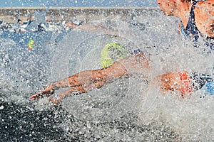 Triathlon participants running into the water for swim portion of race photo