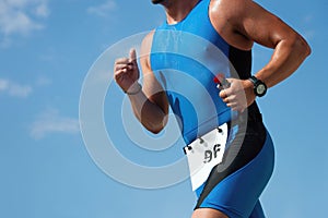 Triathlon runner triathlete man running in tri suit at ironman competition race