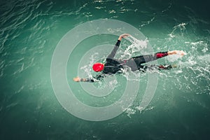 Triathlon swimmer churning up the water in the sea. Athlete practicing for triathletic race in lak