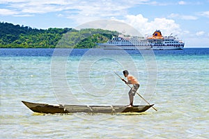 Native boy paddling handmade canoe in front of cruise liner, Solomon Islands