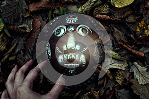 Tribal mask in the autumn woods photo