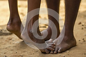 a tribal son playing with his father by feet. photo