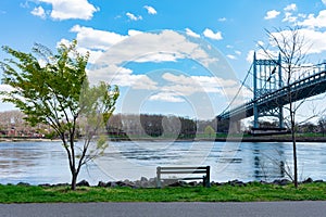 The Triborough Bridge over the East River seen from Randalls and Wards Islands of New York City with a Bench