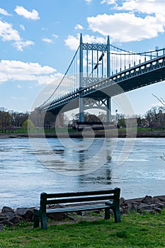 The Triborough Bridge over the East River seen from Randalls and Wards Islands of New York City with a Bench