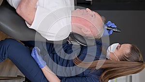 A trichologist conducts a hair diagnosis and examines an older man. Hair treatment concept.