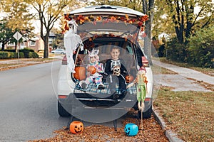 Trick o trunk. Siblings brother and sister celebrating Halloween in trunk of car. Children kids boy and baby girl celebrating